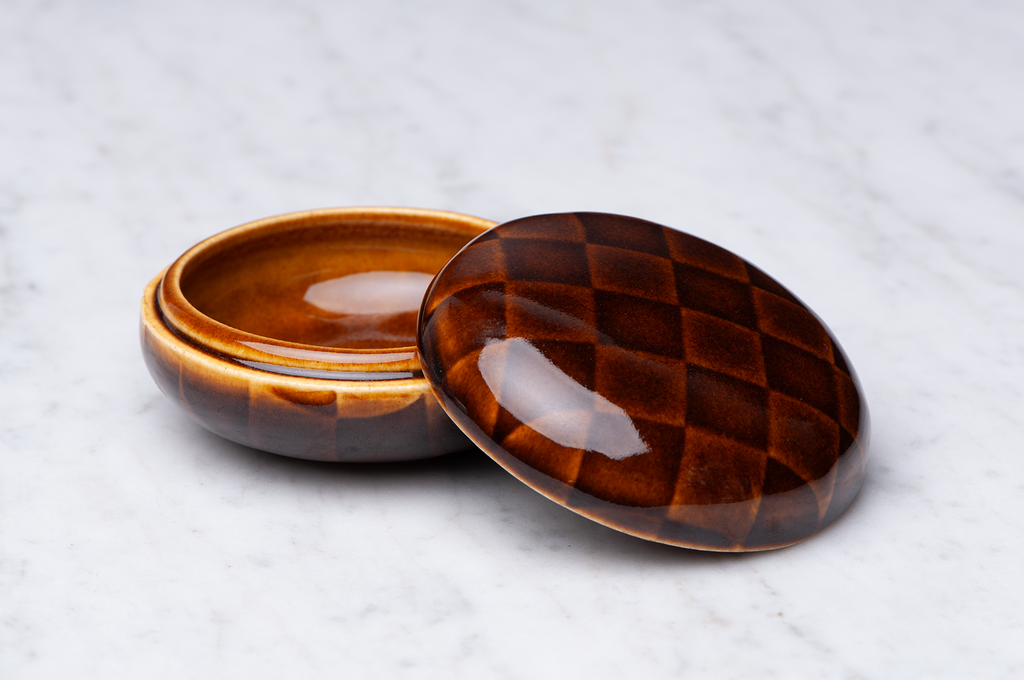 Mörkbrunrutig keramikask med locket på sidan