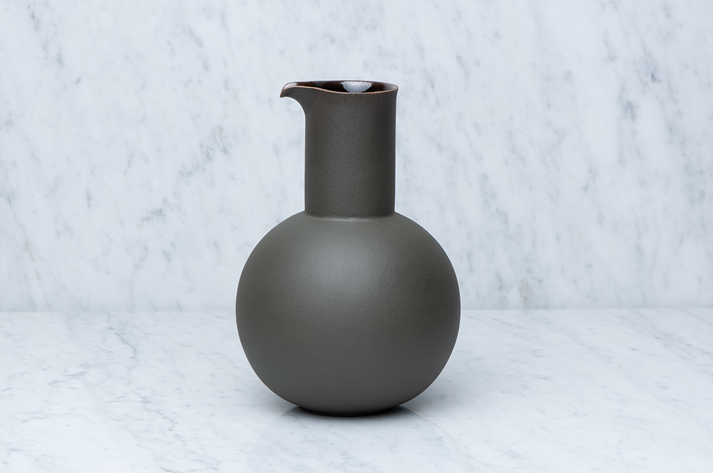 Klotformad mörkgrön keramikkaraff från sidan