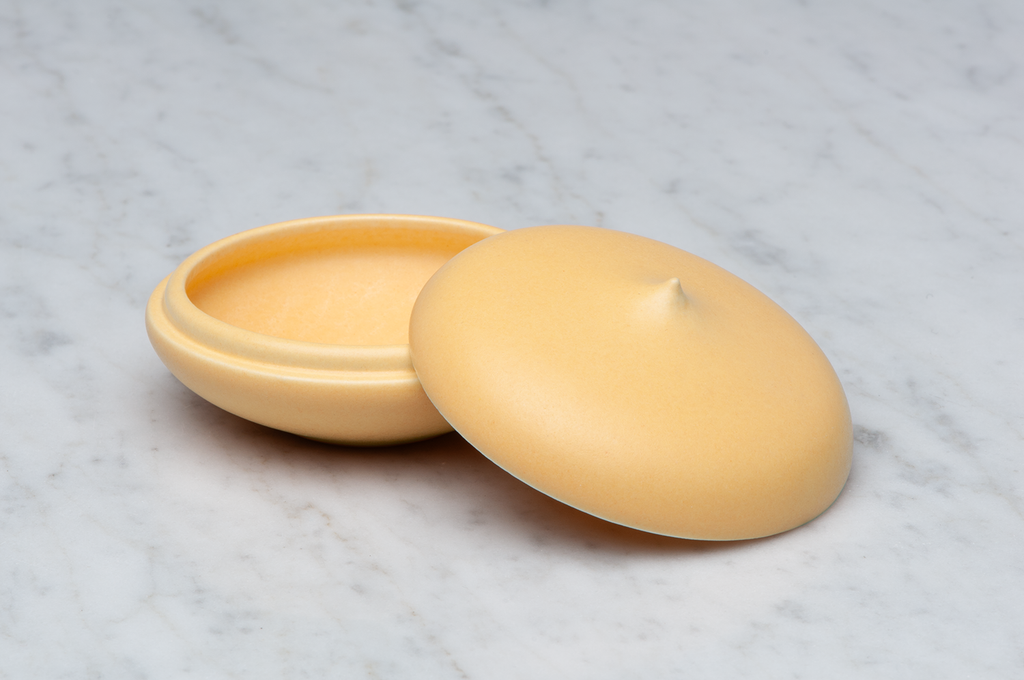 Toppig orange matt keramikask med locket på sidan