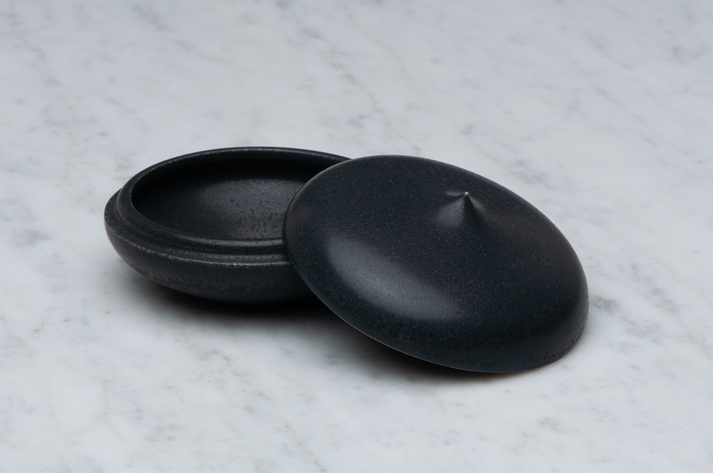 Toppig svart matt keramikask med locket på sidan