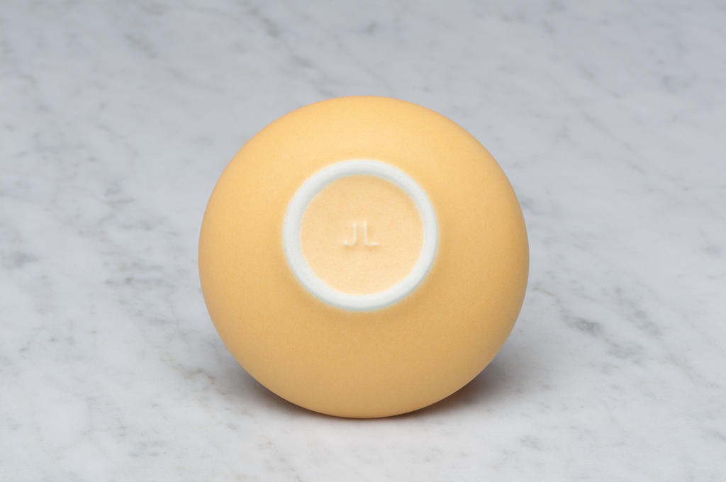 Toppig orange matt keramikask underifrån